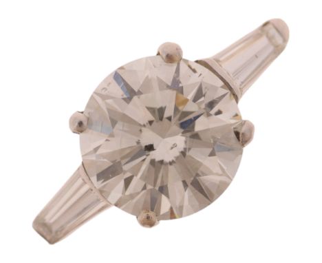 A platinum 2.3ct single stone diamond ring, claw set with 2.3ct natural modern round brilliant-cut diamond flanked by tapered