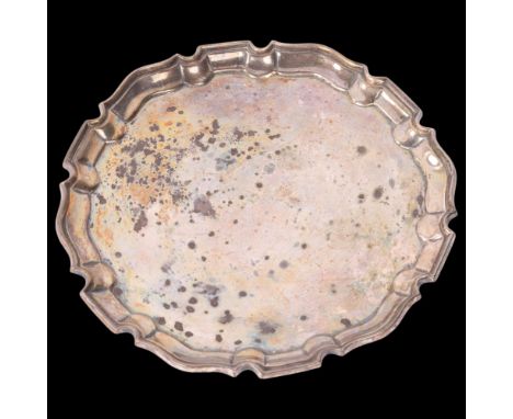 A late Victorian silver salver, Pairpoint Brothers, London 1900, circular form with scalloped rim raised on 3 feet, 14cm, 5.4