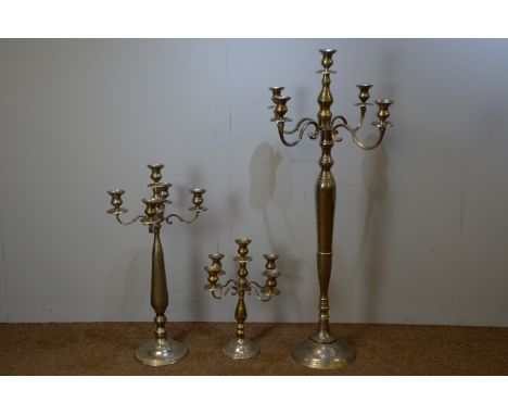 A large plated four-branch five-light candle stand, 71 x 147cms high; and two similar graduated candle stands, 95cms and 57cm