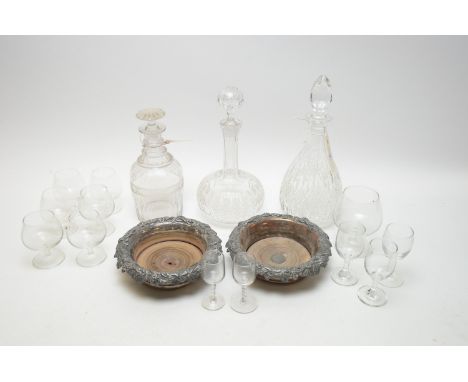 A 19th Century mallet shaped decanter; two further cut glass decanters; a pair of copper plated coasters with turned wooden b