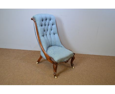 A Victorian carved walnut button-back nursing chair, with scroll frame and legs terminating in ceramic castors, 51 x 96cms hi