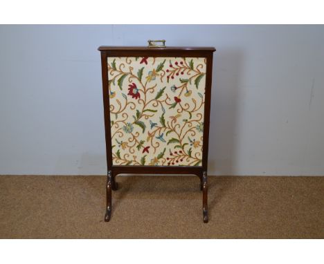 A late Victorian firescreen, rectangular, with ornate brass handle, fitted with later needlework panel, on downswept feet, 64