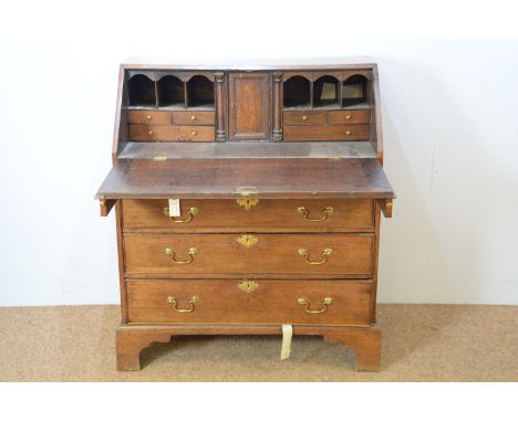 A Georgian oak bureau, with rectangular writing slope and fitted interior, above four long graduated drawers, on bracket feet