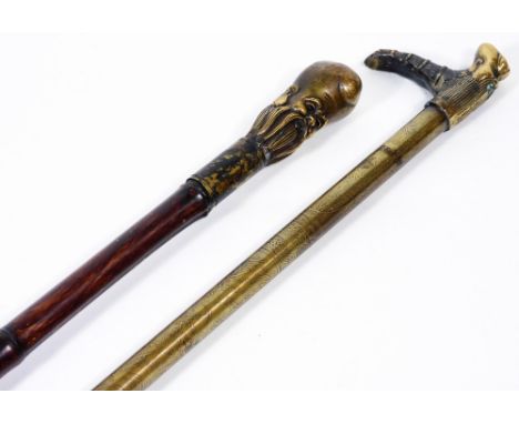 A Chinese bamboo type walking stick, with rubber end and metal top, set with a figure of a bearded sage, 92cm H, and a furthe