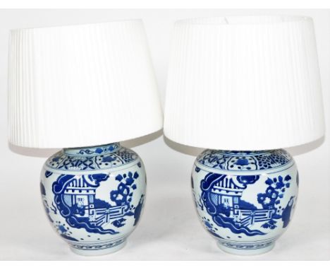 Two Qing style blue and white Chinese porcelain lamp vases, of large proportion, with fixed lids, each body profusely decorat