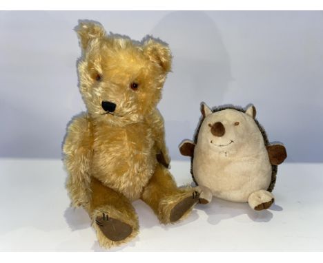 An early 20th Century wood wool filled teddy bear, possibly by Chiltern, with golden mohair jointed body, non functioning gro