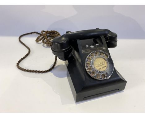 A black Bakelite rotary dial telephone and handset