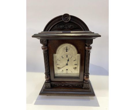 An early 20th Century stained wood bracket clock of architectural form, having silvered dial and two train movement, 48cm H
