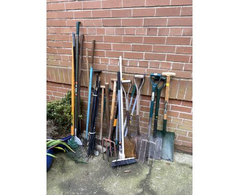 A selection of garden tools including rakes and spades