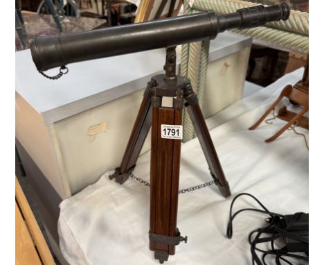 A patinated brass telescope on wooden tripod stand