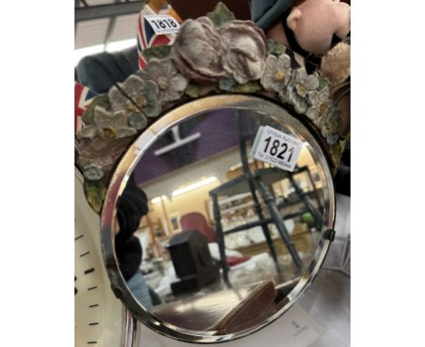 A round bevel edge mirror with part floral frame