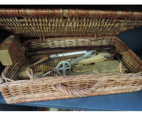 A basket of traditional butter making and dairy equipment including treen framed milk thermometer, butter pats, butter stamps