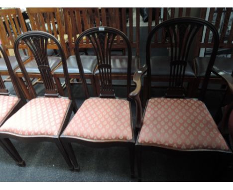 A set of five (4+1) early 20th century mahogany dining chairs having arch slat backs, later upholstered seats and tapered leg