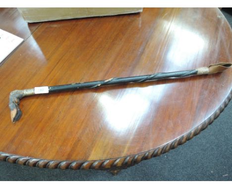 A riding crop with deer foot handle decorative ferule and snake design on stick