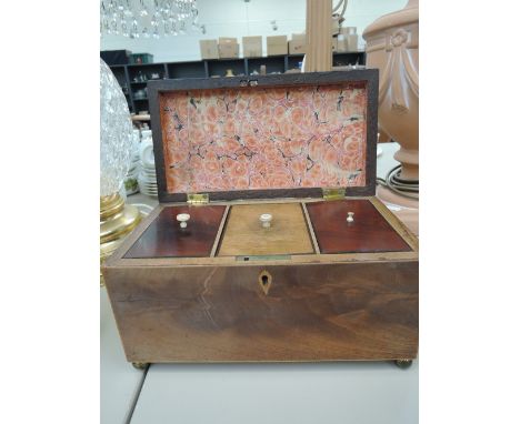 A 19th century mahogany tea caddy having fitted interior and brass bun feet