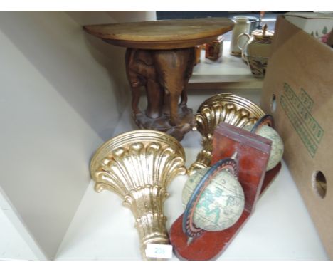 A pair of gilt plaster wall brackets, a treen carved elephant, and globe book ends