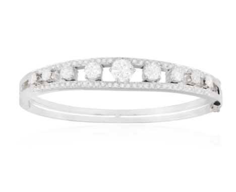 A DIAMOND BANGLEThe hinged bangle, the frontispiece set with graduating European-cut diamonds between single-cut diamond bord