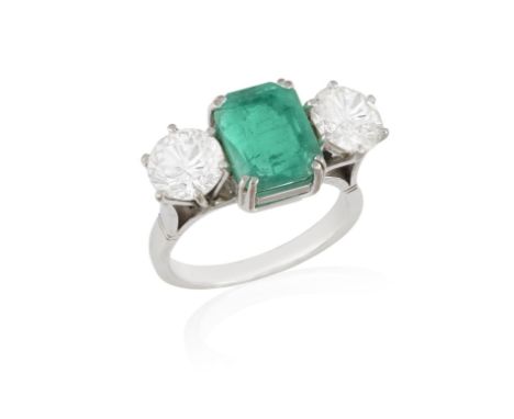 AN EMERALD AND DIAMOND THREE-STONE RINGThe cut-cornered rectangular-cut emerald weighing approximately 3.00cts, between brill