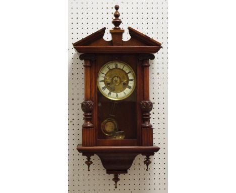 A reproduction acanthus capped mahogany pine and walnut wall clock, with porcelain dial, Roman numerals, pendulum and key 