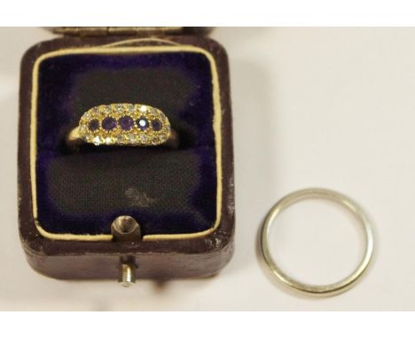 An Edwardian yellow metal ring inline set with five round sapphires surround by eighteen round diamonds, pierced sides size K