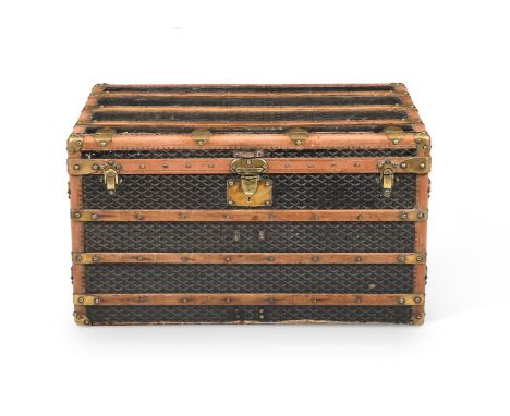 A JACQUARD CHEVRON COATED CANVAS TRAVELLING TRUNK, NO. 279913 E. GOYARD, 20TH CENTURY With leather and brass trim, wooden sla