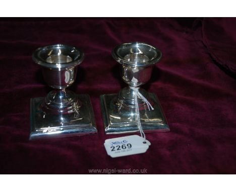 A pair of Silver dumpy Candlestick standing on square bases, dated after 1970