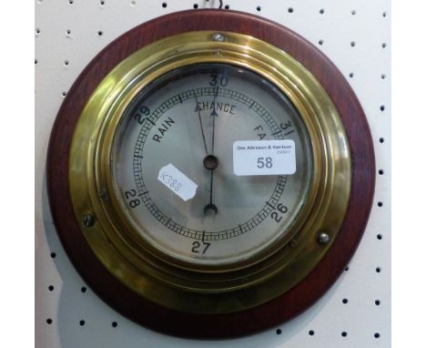 A brass cased wall barometer on wooden base