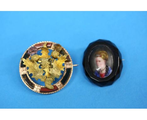 A Victorian jet brooch mounted with a porcelain portrait plaque and a gold coloured agate and thistle design Scottish brooch.