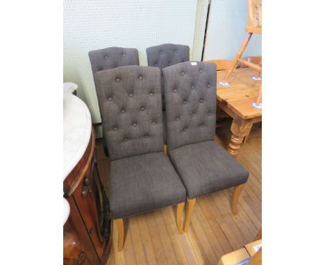 A set of four modern button back dining chairs on light oak out swept legs 