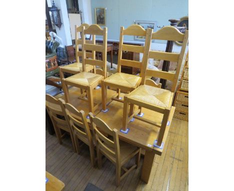 A contemporary light oak extending dining table on legs of square section along with ten conforming ladder back dining chairs