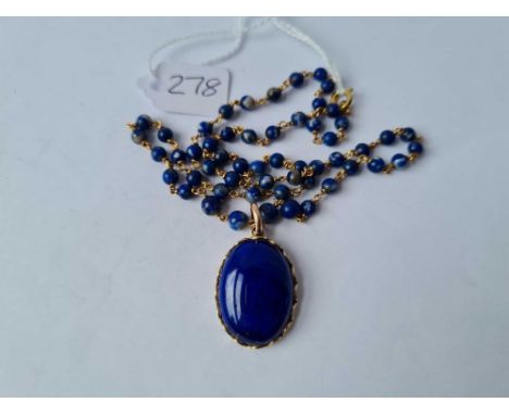 A vintage lapis and gold necklace and pendant set in decorative gold