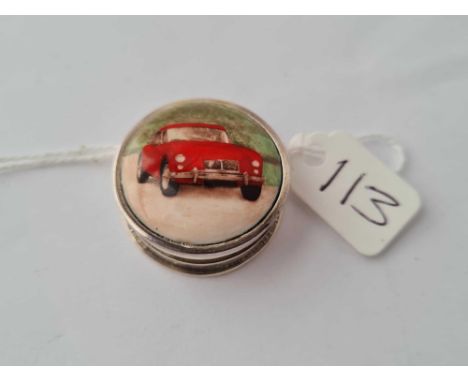 A pretty circular silver and enamel topped pill box depicting a red MG car