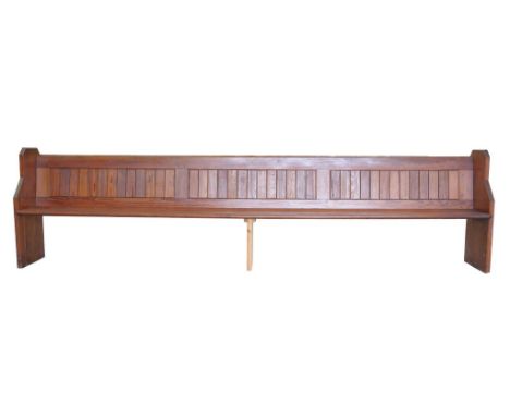 An Early 20th Century pitch pine church pew  with a plank back and fitted rear book trough, 355 x 92 x 38 cms.