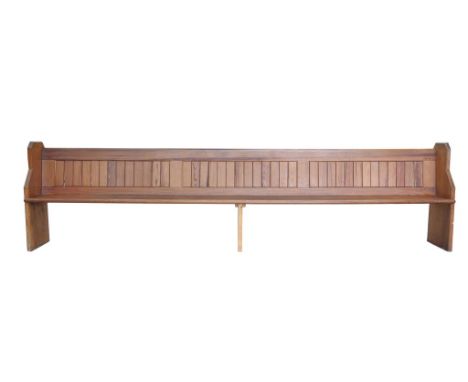 An Early 20th Century pitch pine church pewwith a plank back and fitted rear book trough, 355 x 92x 38 cms.