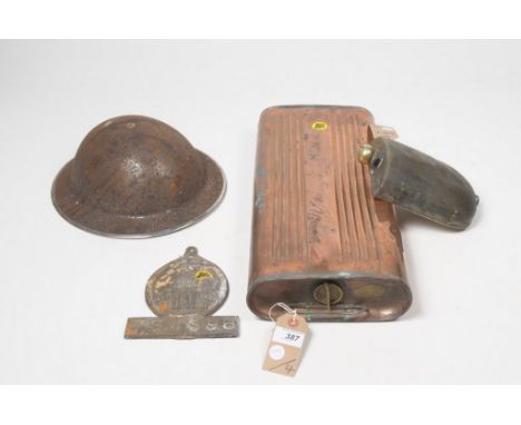 A mixed collection of metalwaresTo include a copper cylinder bed warmer, a tinplate flask, a WWII helmet and an antique wall-