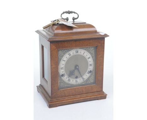 An early 20th Century quarter chiming walnut cased mantel clockThe domed architectural case with glazed door, raised on a bev