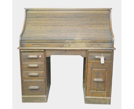 An Early 20th Century oak roll top deskThe rectangular top above an " S " form tambour front ( a/ f )  enclosing an arrangeme