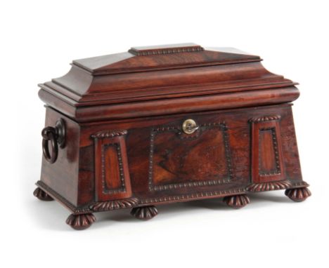 A FINE REGENCY ROSEWOOD EGYPTIAN REVIVAL TEA CADDY of sarcophagus form with gadrooned mouldings and hoop handles, the hinged 