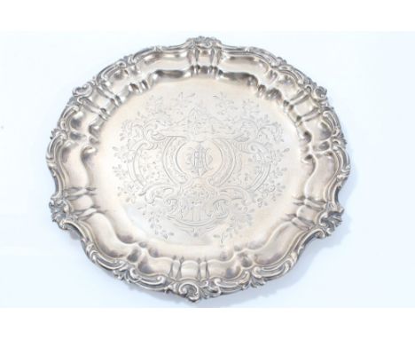 Victorian silver waiter of circular form, with rococo scroll and piecrust border and engraved arabesques with courting couple