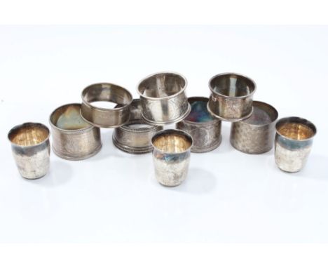 Seven silver napkin rings - various and three white metal tots (10), 7ozs