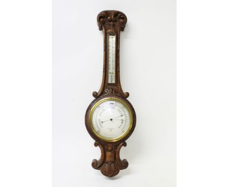 Late Victorian aneroid barometer / thermometer, by Negretti & Zambra, London, with ornate carved oak banjo-shaped case, 92cm