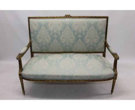 Louis XIV-style carved giltwood sofa with square pad back and seat, with ribbon and stiff leaf-carved show-wood frame, raised