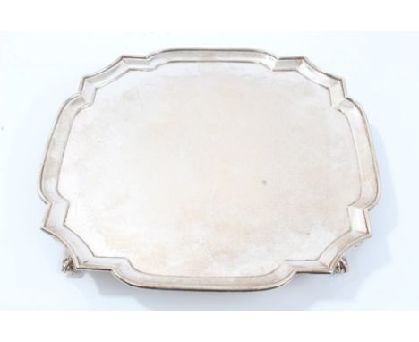 1920s silver salver of shaped square form, with piecrust border, on four ball and claw feet (London 1927), Russell & Co. Ltd.