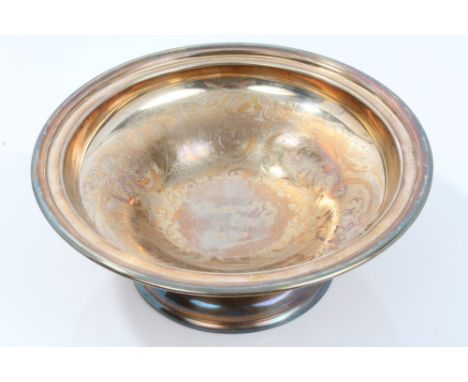 Contemporary silver fruit bowl of circular form, with engraved foliate decoration and presentation inscription, on circular p