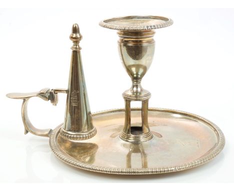 George III silver chamber candlestick of conventional form, with gadrooned borders, engraved crest, central wick-trimmer aper
