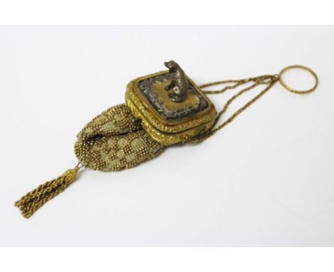 Late 19th century gilt metal mounted beadwork purse, the push button hinged cover surmounted by a white metal model of a houn