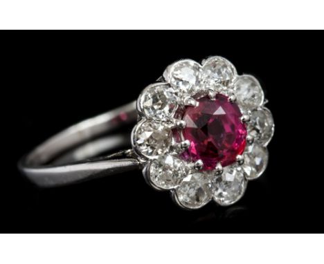 Ruby and diamond cluster ring, the flower-head cluster with a central mixed cut ruby weighing 1.30 carats, surrounded by a bo