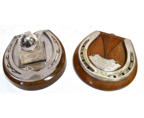 A GLASS INKWELL with riding hat, hinged cover on a horseshoe stand with oak base, 16cm high, 14.5cm wide, 10cm deep; together
