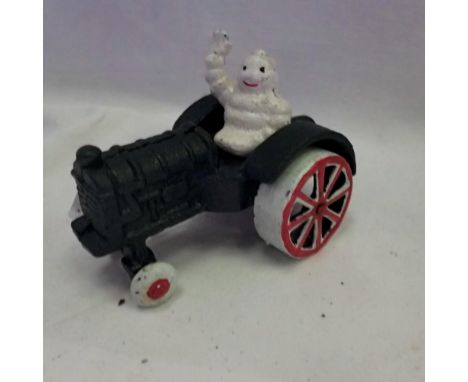 Cast iron Michelin man on tractor, L: 11 cm. UK P&amp;P Group 1 (£16+VAT for the first lot and £2+VAT for subsequent lots)