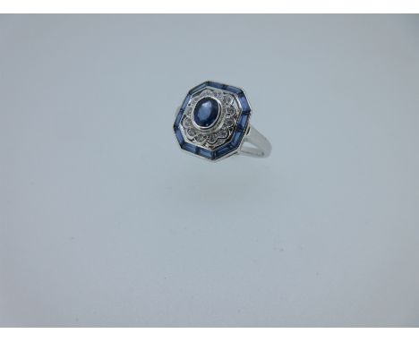 set to the centre with an oval cut light blue sapphire in a petal edge border of round brilliant cut diamonds, and a pierced 